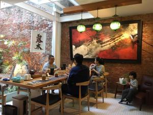 a group of people sitting at a table in a restaurant at 一起-台南 雙人套房 in Tainan