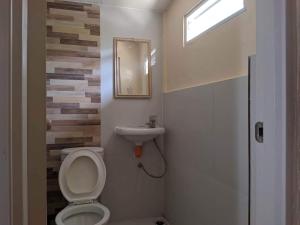 ein Bad mit einem WC und einem Waschbecken in der Unterkunft Miguel's Homestay in Pañge