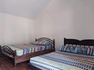 twee bedden naast elkaar in een kamer bij Miguel's Homestay in Pañge