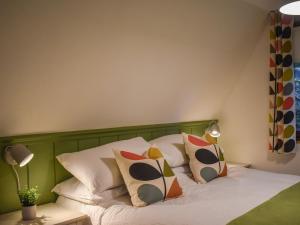 a bedroom with a bed with colorful pillows on it at Pine Needle Lodge in Kilfinnan