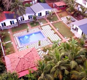 an aerial view of a house with a swimming pool at White Truffle Resort, Arambol in Arambol