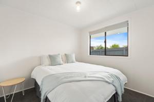 1 dormitorio con cama y ventana en Garden Grove Gem - Lake Taupō Holiday Home, en Taupo