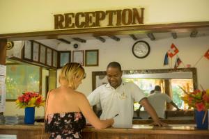 a man and a woman standing at a counter at Mnarani Beach Cottages in Nungwi