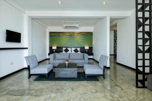 uma sala de estar com um sofá, cadeiras e uma mesa em Splendour Residence em Balapitiya