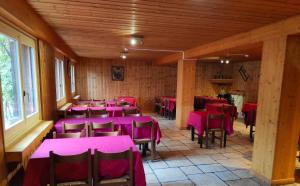 uma sala de jantar com mesas e cadeiras cor-de-rosa em Auberge de Pra-Loup em Pra-Loup