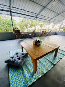 Petit Ana Beach Retreat في فاركَالا: طاولة خشبية موضوعة فوق سجادة