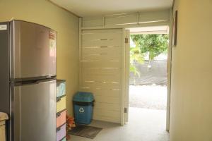 cocina con nevera y puerta abierta en Gala Apts, en Santa Teresa Beach