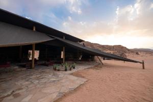 a building in the desert with plants in front of it at Sinam Desert Resort in Wadi Rum