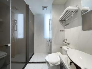 a bathroom with a shower and a toilet and a sink at CHECK inn Taichung Qinghai in Taichung