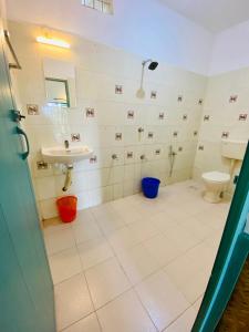 a bathroom with a toilet and a sink at Petit Ana Beach Retreat in Varkala