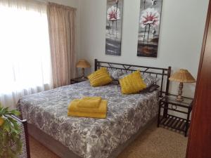 una camera da letto con un letto con asciugamani gialli di Pecan Nut Place a Dalmada