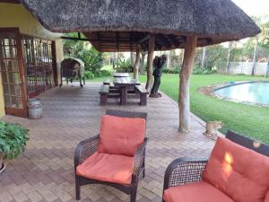 patio z krzesłami i stołem oraz basenem w obiekcie Pecan Nut Place w mieście Dalmada