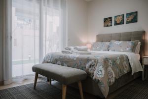 a bedroom with a bed with a chair and a window at Nafplio Pleasure Stay Ι in Nafplio