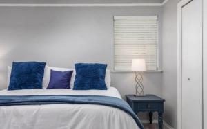 Un dormitorio con una cama con almohadas azules y una ventana en Summer Deal! Air Force 1 Heroes Home - Sheppard AFB Wichita Falls, en Wichita Falls