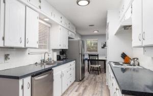 a kitchen with white cabinets and a black counter top at Summer Deal! Air Force 1 Heroes Home - Sheppard AFB Wichita Falls in Wichita Falls