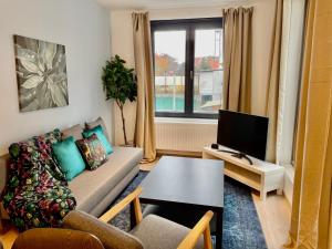 a living room with a couch and a tv at OneLuxStay near Fashion District in Antwerp