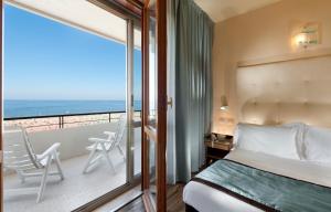 a bedroom with a bed and a balcony with the ocean at Yes Hotel Touring & SPA in Rimini