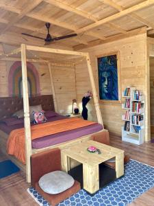 a bedroom in a log cabin with a bed and a table at Love Temple Beach Resort in Arambol