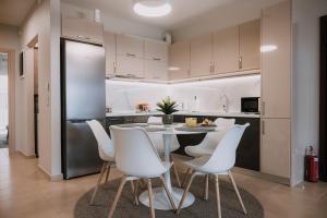 a kitchen with a table and white chairs at Nafplio Pleasure Stay Ι in Nafplio
