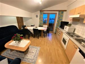 eine Küche und ein Wohnzimmer mit einem Tisch und einem Sofa in der Unterkunft Lovely Apartment in Saalfelden directly on the farm in Saalfelden am Steinernen Meer