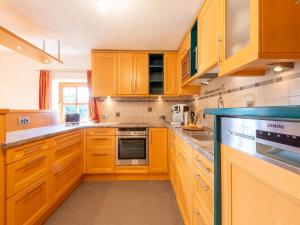 a kitchen with wooden cabinets and a stove top oven at Property in Saalfelden in Saalfelden am Steinernen Meer