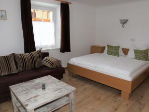 mała sypialnia z łóżkiem i kanapą w obiekcie Chalet in Bramberg near Wildkogel Arena w mieście Bramberg am Wildkogel