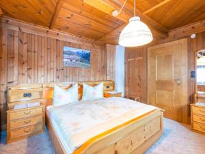 um quarto com uma cama e uma parede de madeira em Cozy holiday home in Hochfilzen with mountain views em Hochfilzen