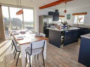 une cuisine avec une table et des chaises dans l'établissement Pastures Barn, à Leek