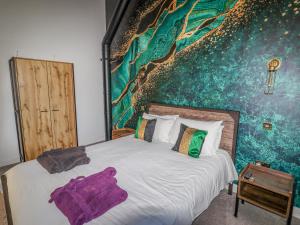 um quarto com uma cama grande e um mural de parede em Pastures Barn em Leek