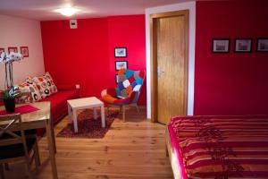 B&B Les Biolleys في Vex: غرفة معيشة حمراء مع أريكة وطاولة