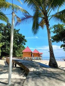ośrodek wypoczynkowy na plaży z dwoma palmami w obiekcie Sing Key Beach w mieście Masohi