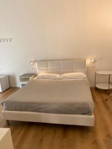 1 dormitorio con 1 cama blanca y 2 mesas en Civico 28, en Pescara