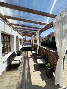 a patio with benches and a car parked under a pergola at Városi Idill in Veszprém