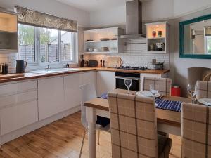 a kitchen with a table and a dining room at The Warblers in Minehead