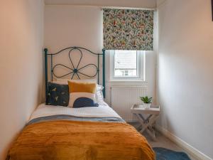 a bedroom with a bed and a window at The Warblers in Minehead