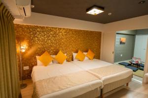 um quarto com uma cama grande e almofadas amarelas em Japan Hinata Hotel 池下駅徒歩2分 1LDK 50平米 8名 em Nagoia