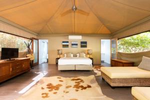 um quarto com uma cama e uma televisão de ecrã plano em The Billi Resort em Broome