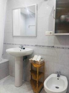 ein weißes Bad mit einem Waschbecken und einem WC in der Unterkunft Avenida Apartamento in Oviedo