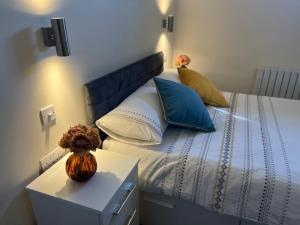 Schlafzimmer mit einem Bett mit blauen und weißen Kissen in der Unterkunft Pods of Kings Cross -1 in London