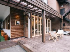 a wooden deck with white chairs and a building at Noasobi Lodge 206- Vacation STAY 45777v in Arao