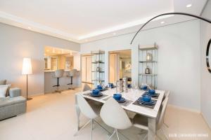 a white dining room with a table and chairs at LUX - The JBR Dubai Eye Suite in Dubai