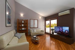 ein Wohnzimmer mit einem Sofa und einem Flachbild-TV in der Unterkunft Biba Lux in Poreč