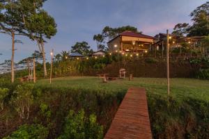 a wooden walkway leading to a house at night at Alam Kita Glamping & Plantation in Munduk