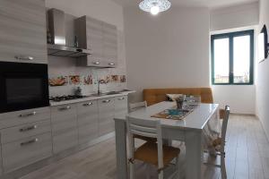 維耶特里的住宿－VerdeMare Charming accommodation in Vietri Sul Mare - Amalfi coast，厨房配有白色的桌椅和电视。