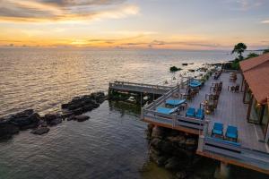 einen Pier mit Stühlen und Tischen auf dem Wasser in der Unterkunft Sea Sense Resort in Phu Quoc