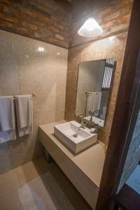a bathroom with a sink and a mirror and towels at The Coastal Village Cabanas in Galle