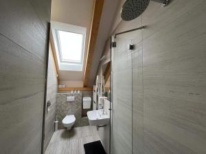 łazienka z toaletą, umywalką i oknem w obiekcie Penzion Kunc - Ubytování v soukromí - Borová 607, Příbram - Střední Čechy w Przybramiu