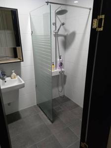 a bathroom with a glass shower and a sink at Sogobe Jeju House in Jeju