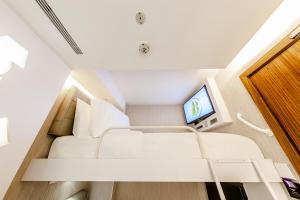 Habitación pequeña con cama y TV. en D'Nova Hotel Bugis en Singapur
