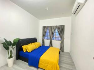 1 dormitorio con 1 cama con manta azul y amarilla en Homestay Kuala Terengganu Affan01 Dekat Pantai Batu Buruk en Kuala Terengganu